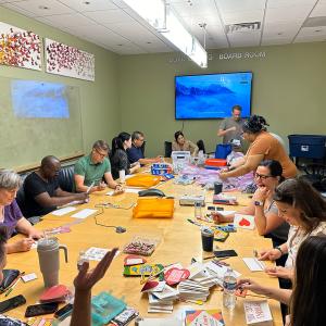 A group seated at a large conference table doing crafts.