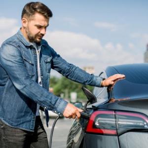 a man charging his electric vehicle