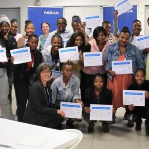 a group of people in a room, many holding certificates