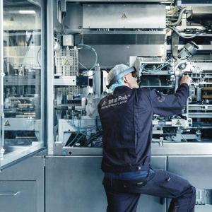 A person working on an open machine.