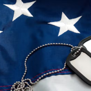 A US flag with 'dog tags' on a chain laid on top.