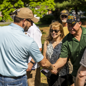 Sgt. David Long shaking hands of others, including veterans
