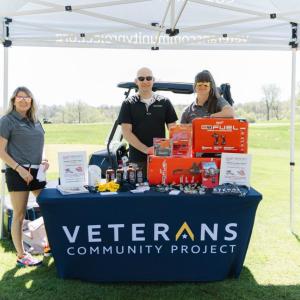 People behind a booth "Veterans Community Project"