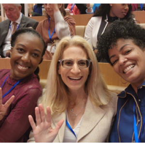 Three people in a selfie seated in an auditorium.