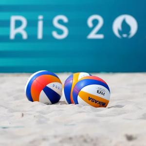 Volleyballs in the sand "Paris 2024" sign in the background.