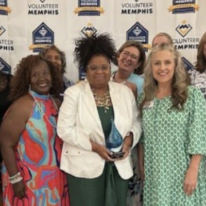 A group of people stood together for a photo in front of balloons 