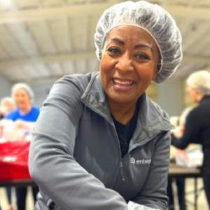 A smiling volunteer in a hair net.