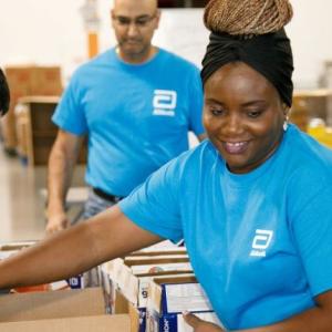 Volunteers in a warehouse setting packing boxes.