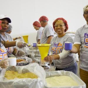 Volunteers scooping food from boxes.