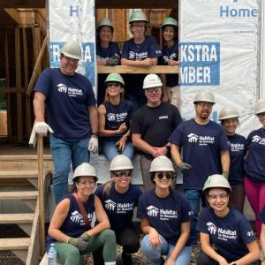 A group of volunteers posed outside a home being built