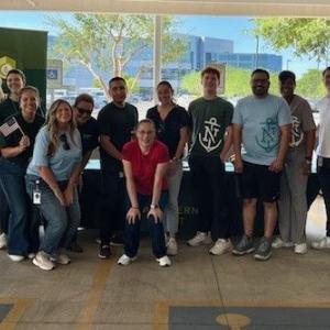A group posed in front of a Northern Trust table and banner.
