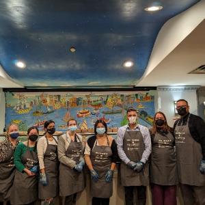 A group of volunteers posed wearing matching aprons.