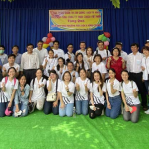 a large group of people outside a building with a poster on it in a foreign language