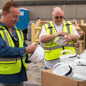 Two volunteers getting hard hats.