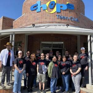 A group of volunteers in matching tshirts in front of a building "Chops tech club