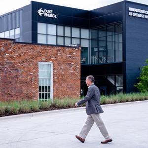 Zhang walking towards a large building