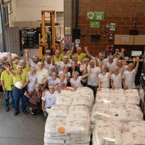 A group of employees posed cheering in a warehouse setting.