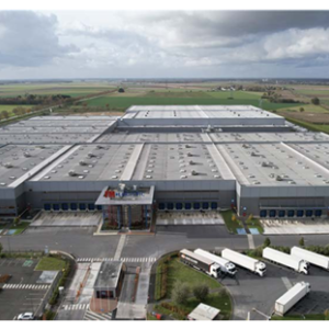 Aerial view of a large warehouse with semi trucks parked in front.