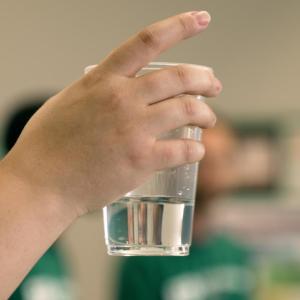 Person holding a glass of water