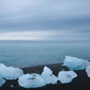 chunks of ice on a beach with open water in the background