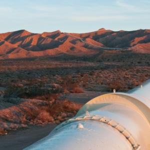 a large pipeline through a desert and mountain landscape