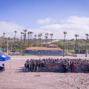 A group of people posed on a large beach.