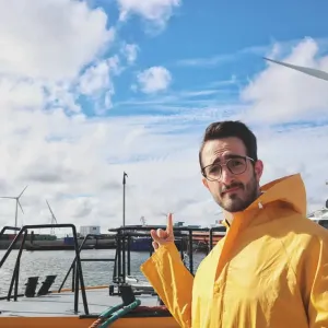 Ruggero Rollini in a rain jacket pointing to the clouds
