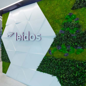 Leidos sign on an interior wall surrounded by greenery.