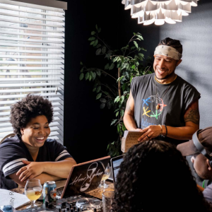 Photo: Werc Crew — XAVIERBLK.COM; people smiling in front of a laptop.