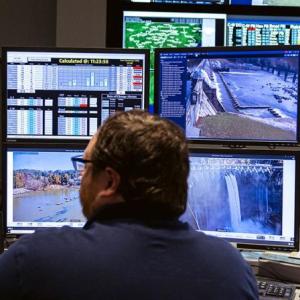 Someone sitting in front of many screens