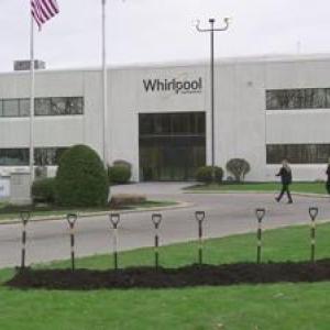outside wide view of Whirlpool office building. Eight shovels standing up in a pile of dirt in front.