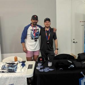 Two people posed behind tables, signs to the sides "White Knight Labs"