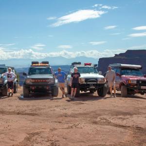 John Mulcahy and family members posed in a scenic natural area each next to an all-terrain vehicle.