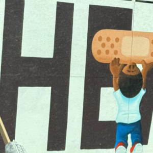 mural with "HEAL" and a child placing a band aid