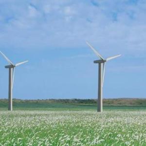 A row of wind turbines in an open field.