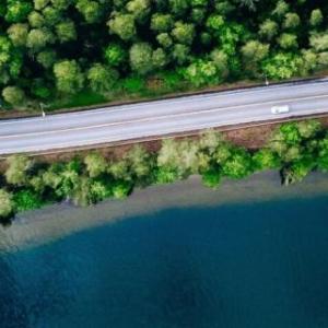 Aerial view of cars on a winding coastal road.