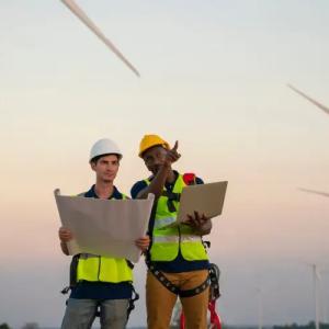 two people standing near windmills