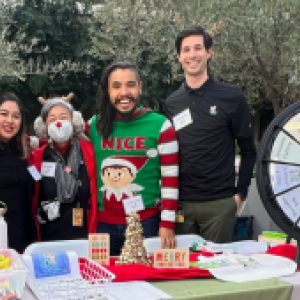 A small group behind a table decorated in festive winter items.