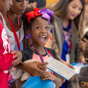 Smiling children and adults in a group.