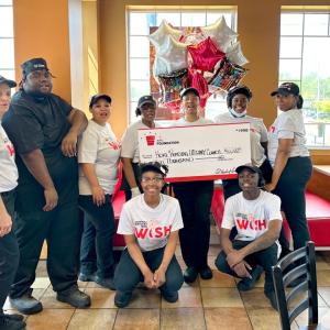 A group of employees posed with a large check