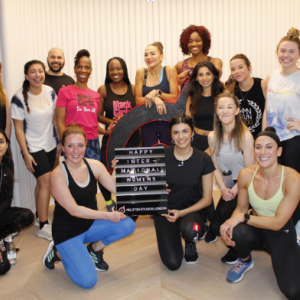 Group ofwomen around a sign that reads "Happy International Women's Day"