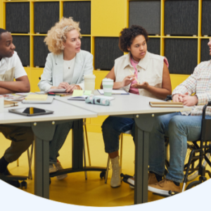 a group of people at a large table, one in a wheelchair