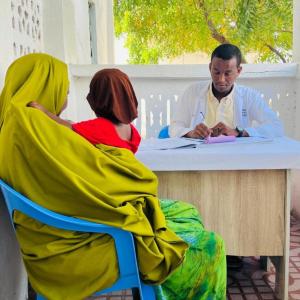 At an Action Against Hunger-supported clinic in Kismayo, a mother discusses vaccination options for her child with a doctor. 