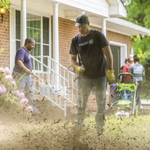 volunteers doing yard work outside the new home