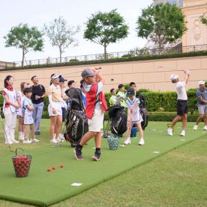 A group of children and adults at a driving range.