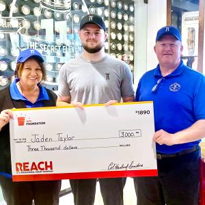 3 people hold a big check together 