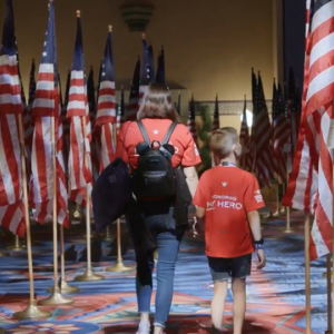children walking through rows of American flags