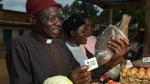 Roger purchases a fish from a local market with his Fresh Food Voucher.