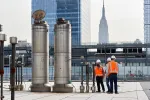 3 workers on a rooftop with the empire state building in the background