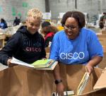 Two people filling  boxes with books